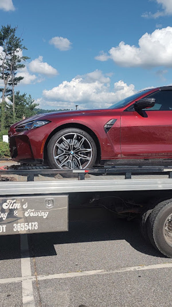 Red sports car loaded on a Tim's Hauling & Towing flatbed